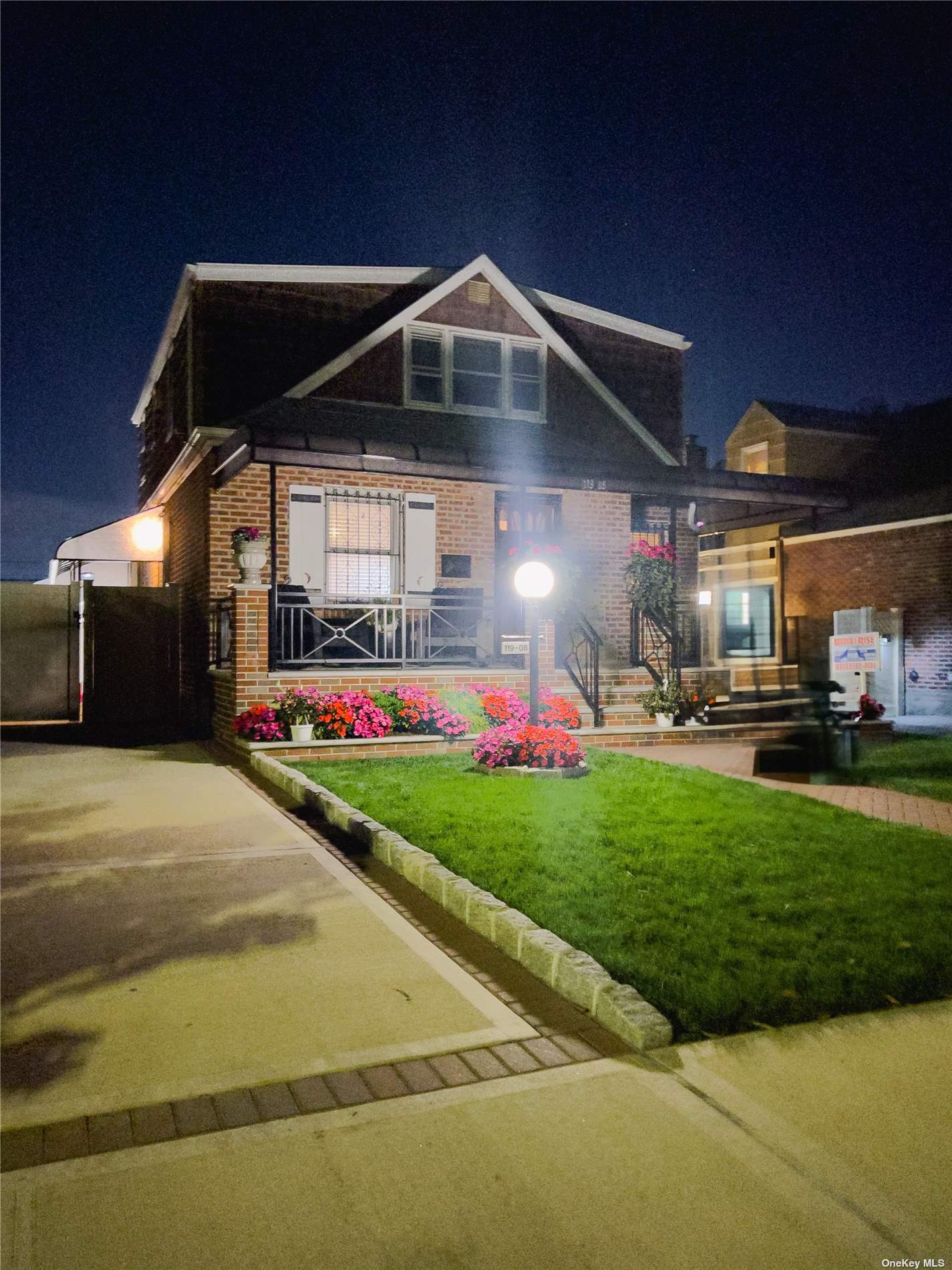 a front view of a house with swing and flower plants