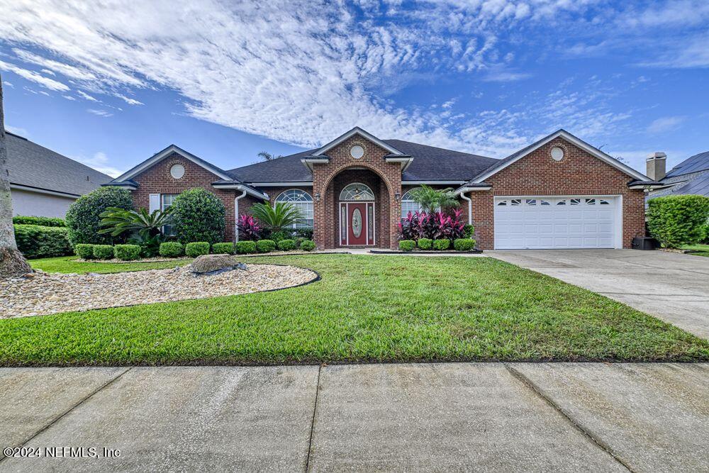 a front view of a house with a garden and yard