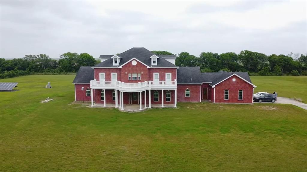 a aerial view of a house with a big yard and large trees