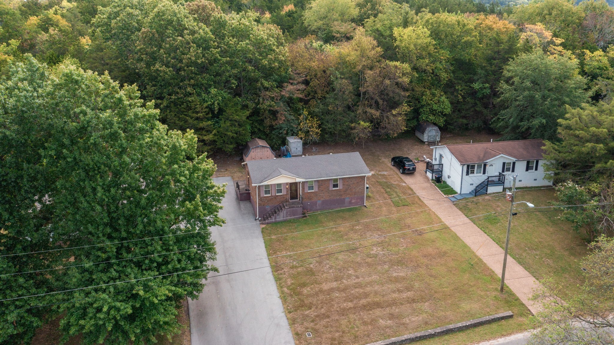 an aerial view of a house with swimming pool and large trees