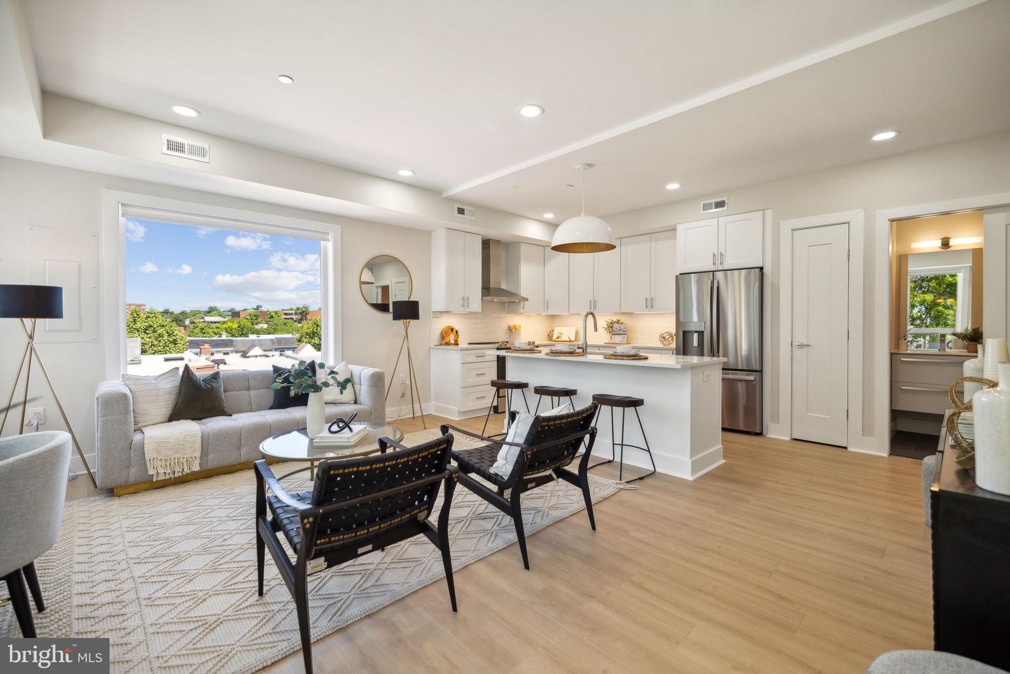 a living room with stainless steel appliances kitchen island granite countertop furniture and a kitchen view