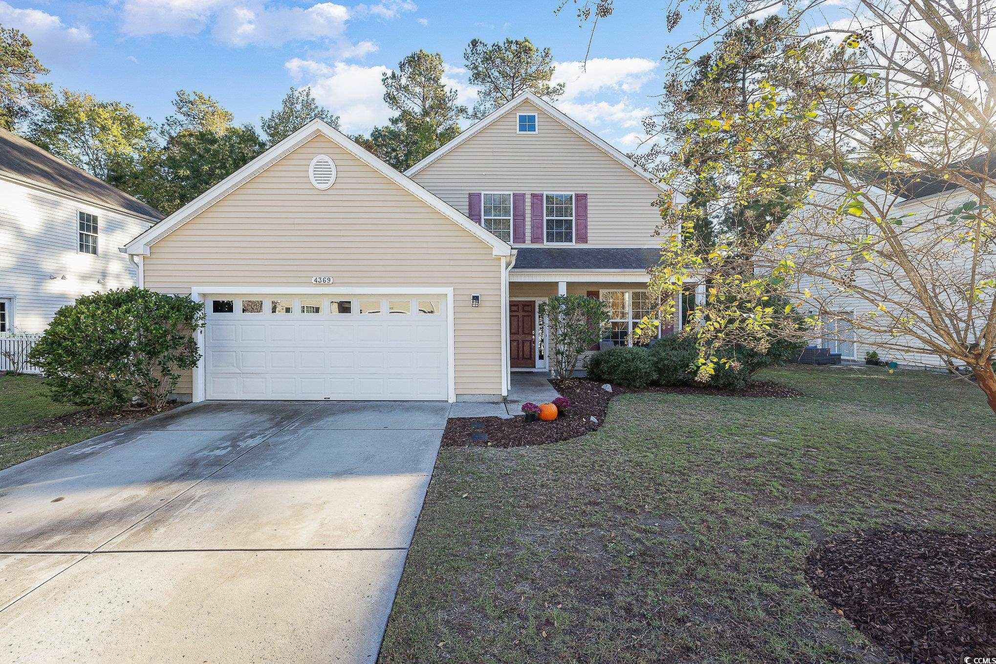 View of property featuring a garage and a front la