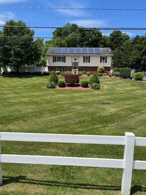 View of front of home with white-picket fence.