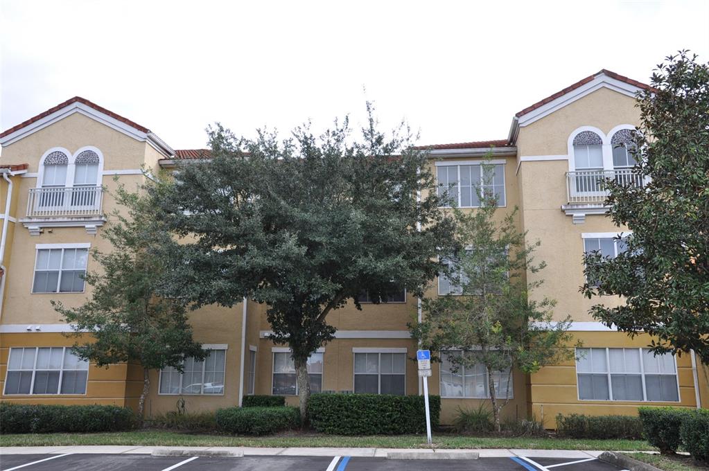 a view of a white house with a clock and a tree