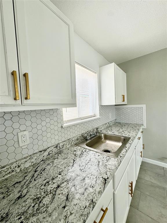 a kitchen with granite countertop a sink and a stove