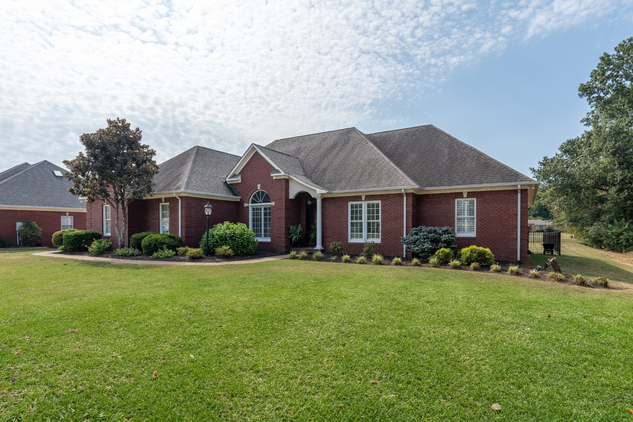 a front view of a house with yard and trees