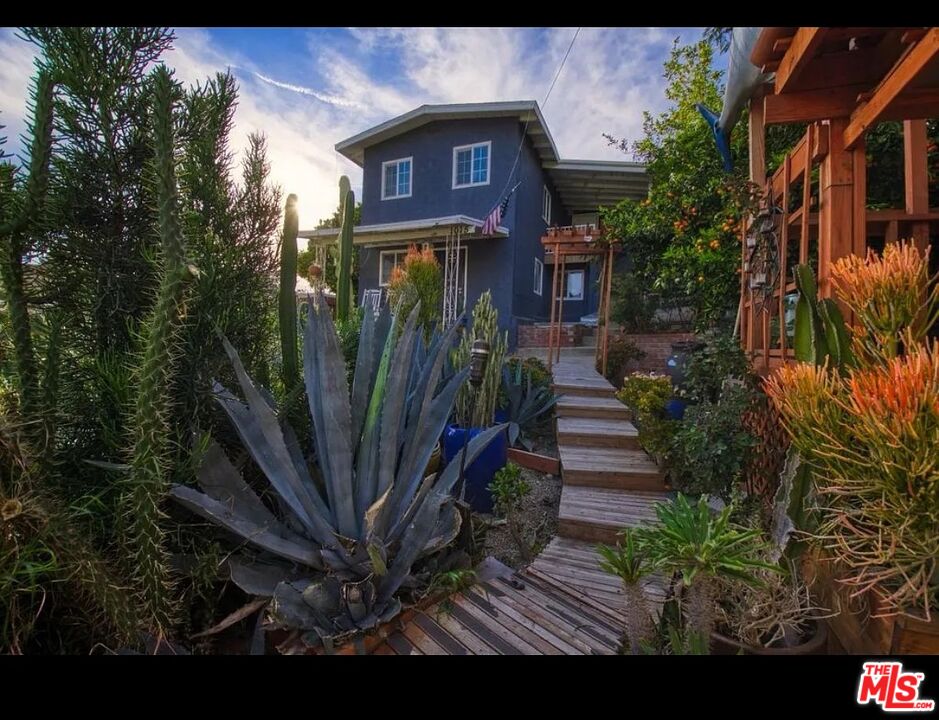 a view of a house with a small yard and plants