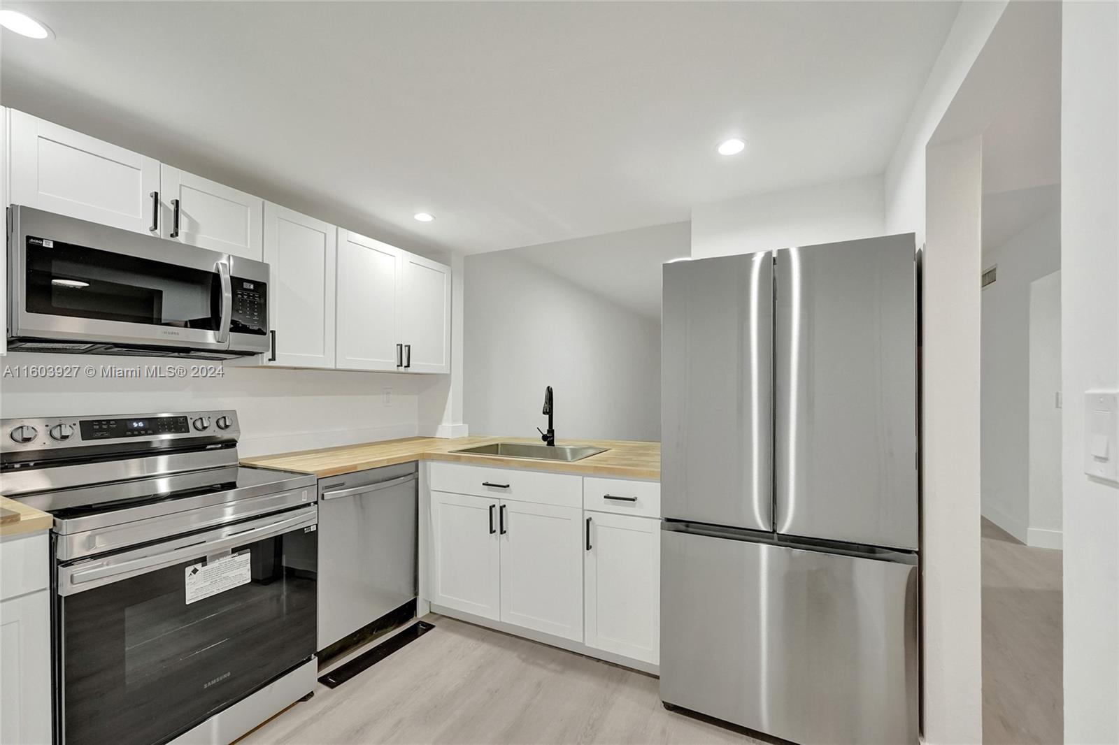 a kitchen with stainless steel appliances a refrigerator sink and microwave