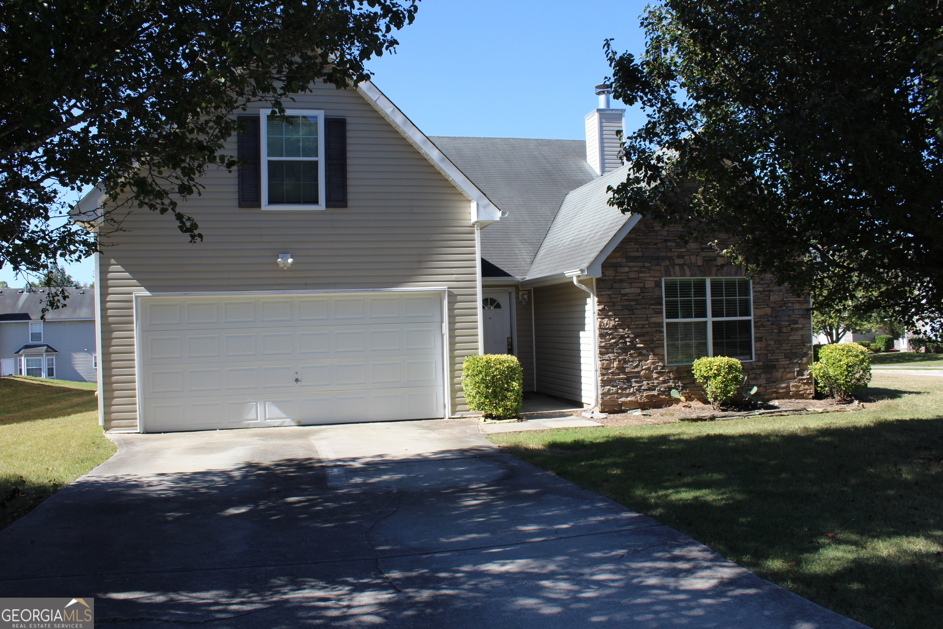 a front view of a house with garden and yard