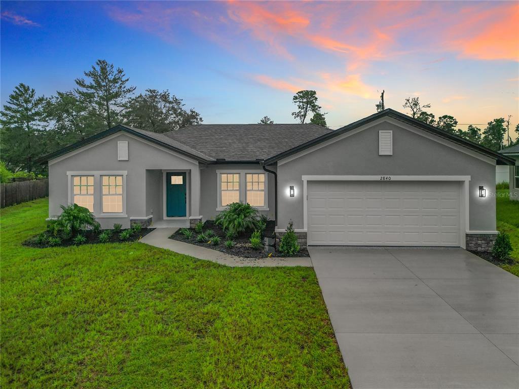 a front view of a house with a yard and garage