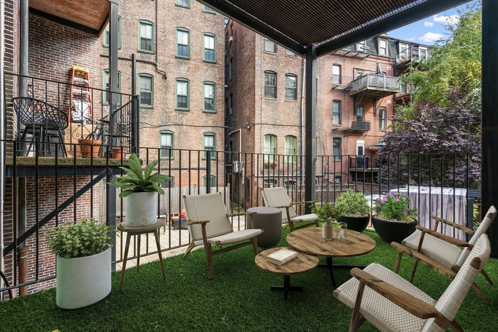 a view of a patio with couches table and chairs and potted plants