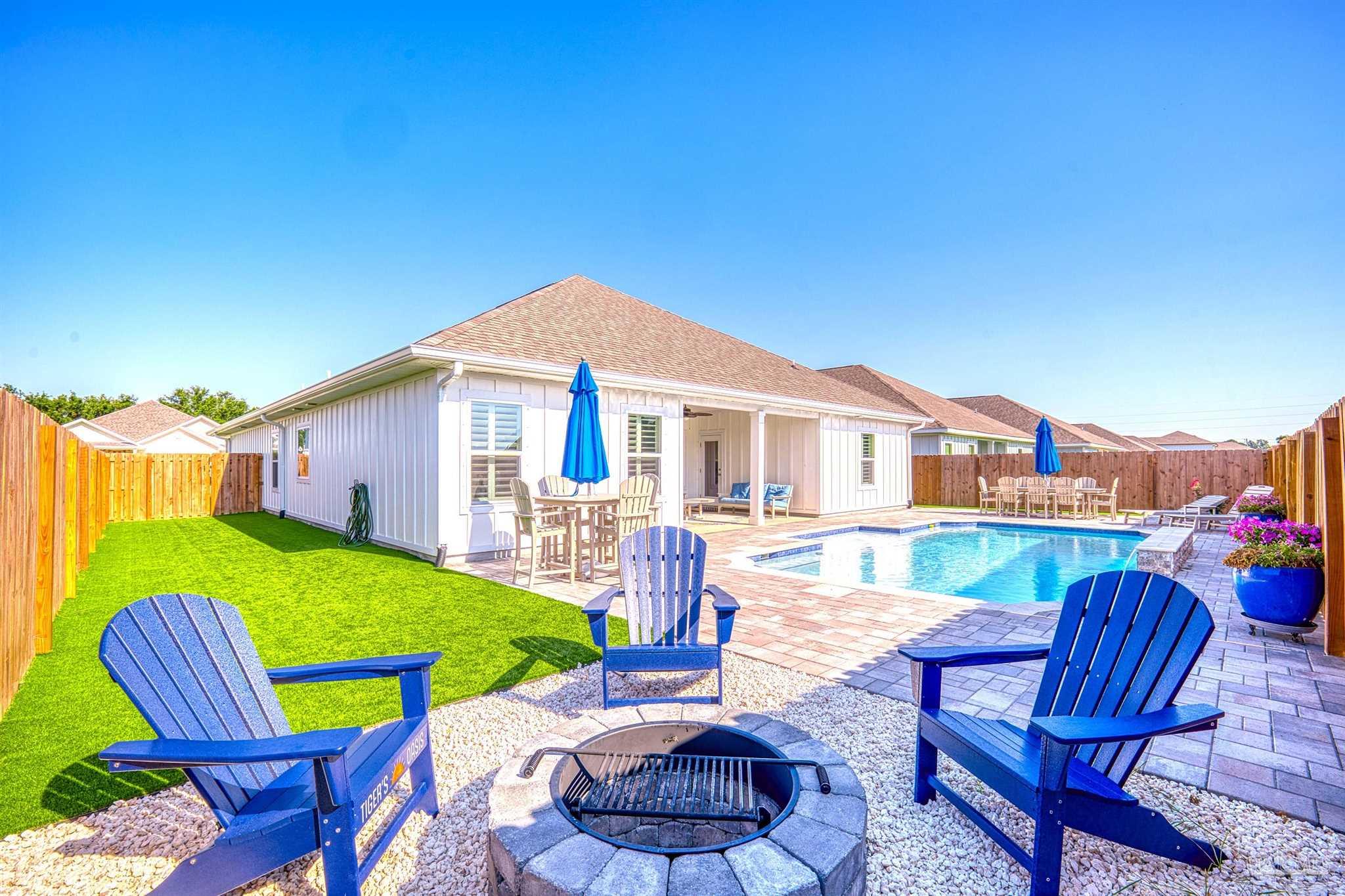 a front view of a house with swimming pool table and chairs