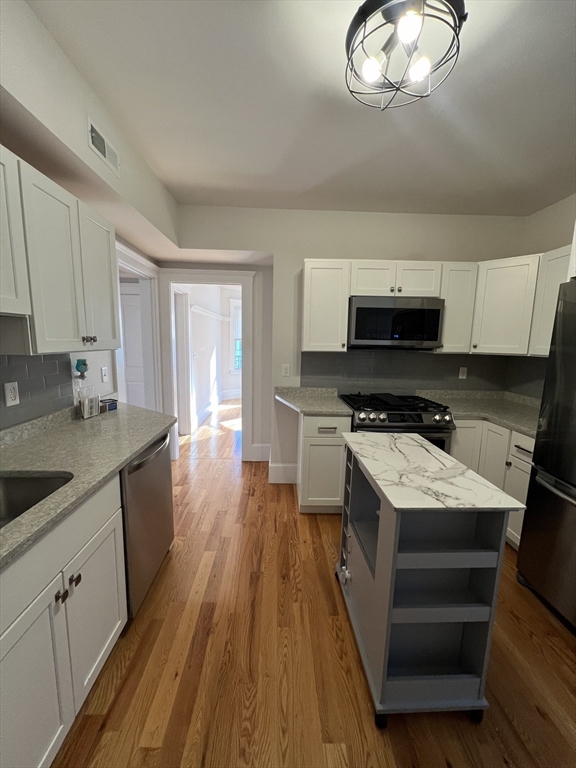 a kitchen with a sink appliances and cabinets