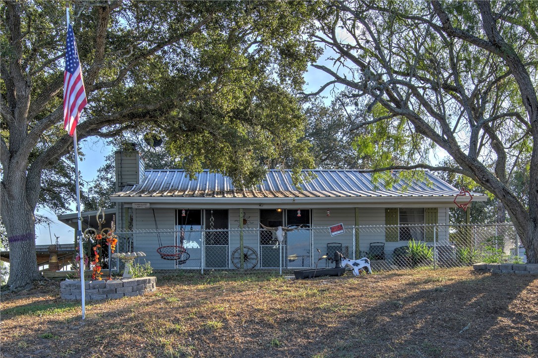 a front view of a house with a garden and tree