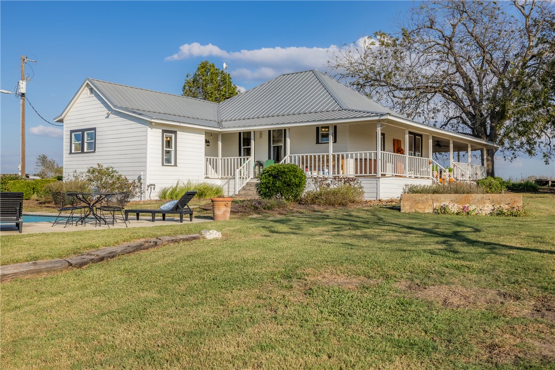 Farmhouse-style home with a porch and a front yard