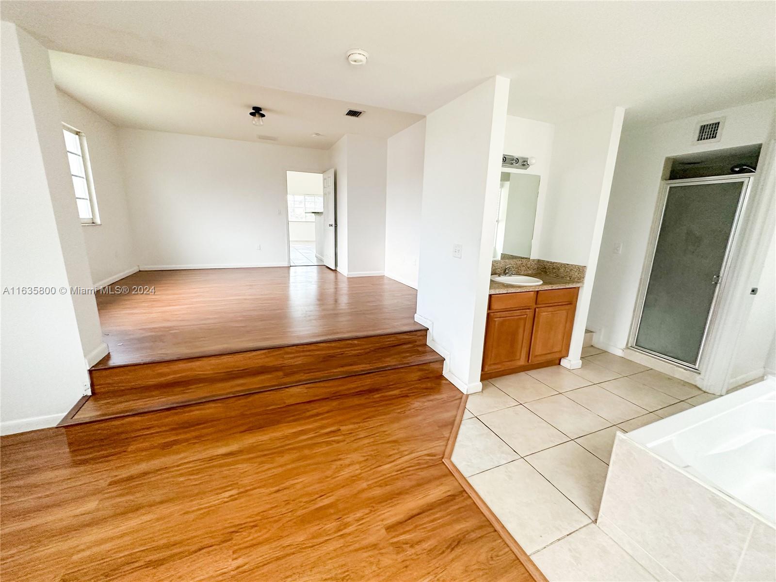 a view of kitchen and hall with wooden floor