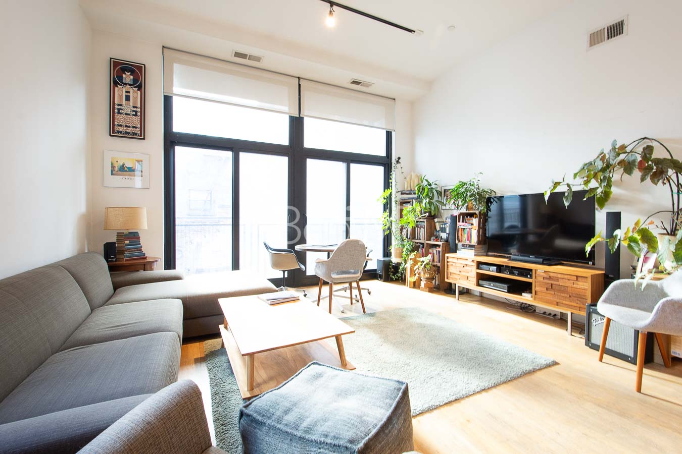 a living room with furniture a flat screen tv and a large window