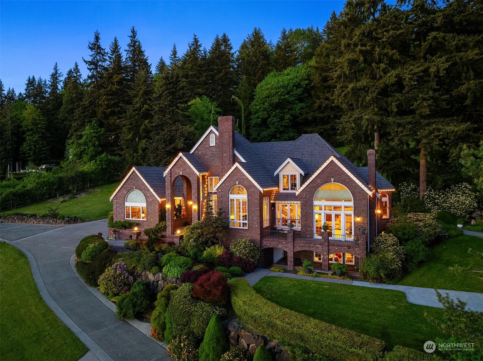 a front view of a house with a garden and trees