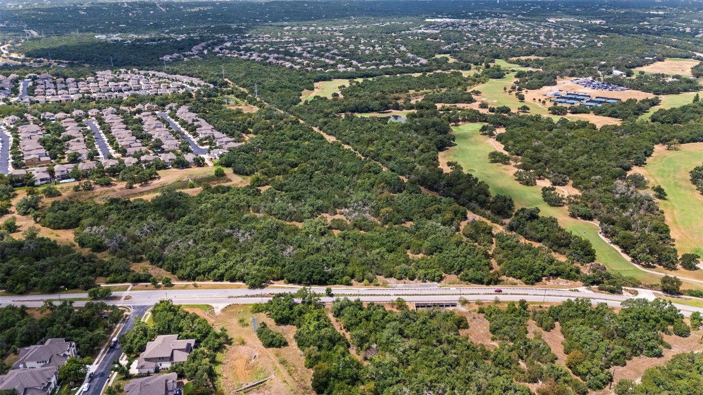 an aerial view of residential houses with outdoor space and trees