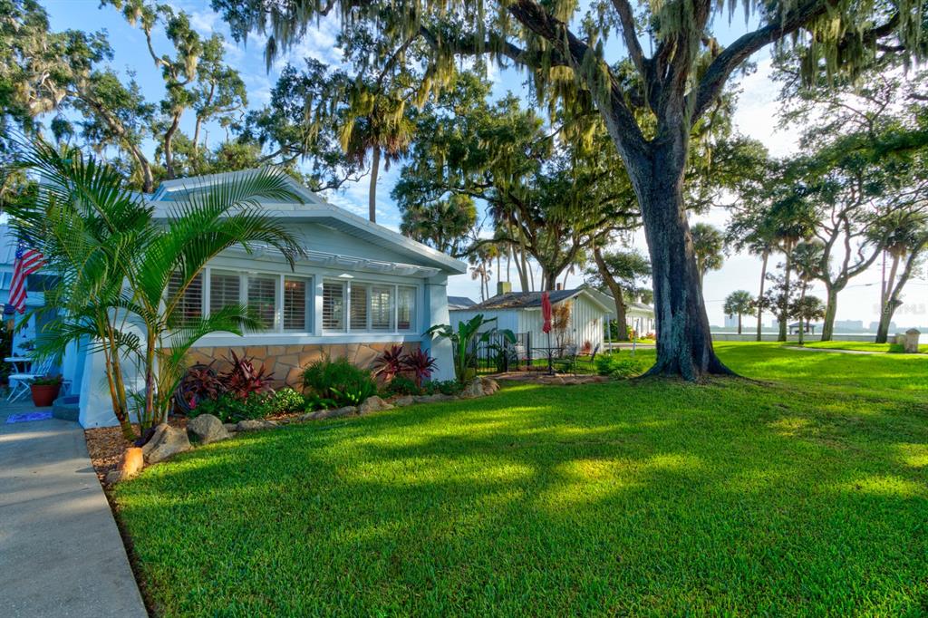 a front view of a house with a garden and trees