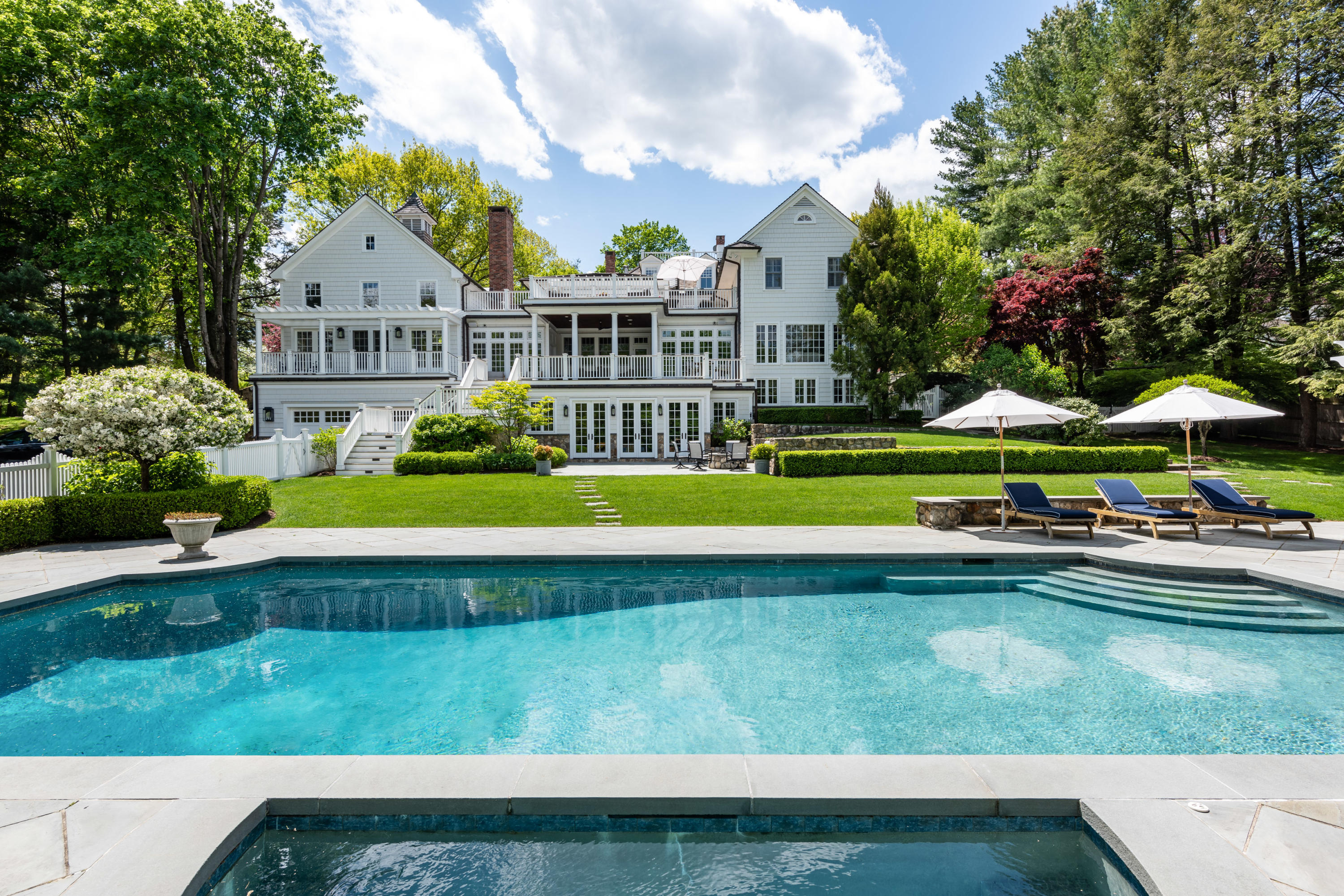 a front view of a house with swimming pool and yard