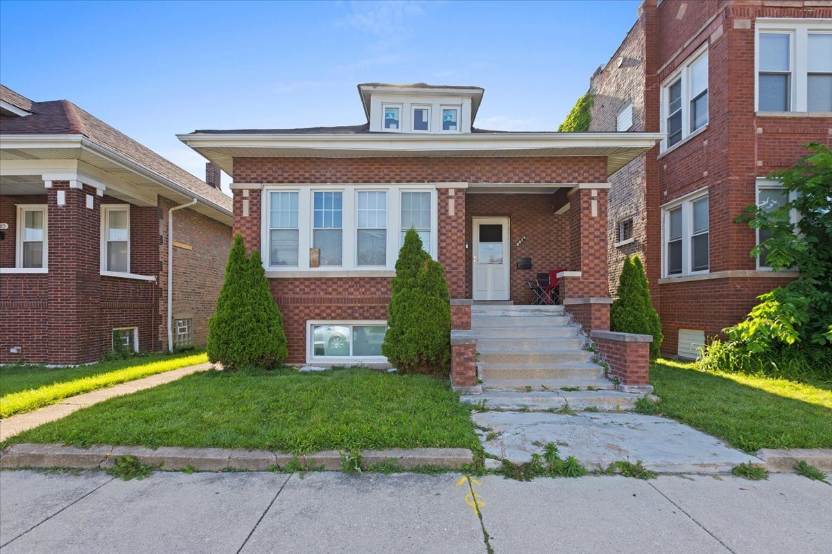 front view of a brick house with a yard