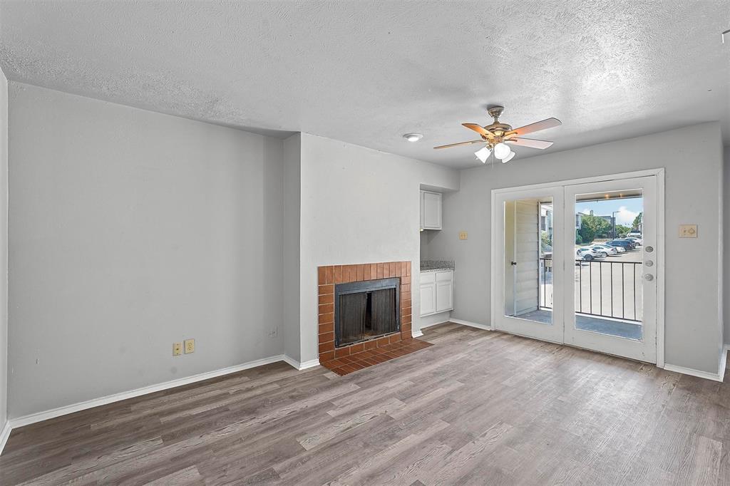 a view of an empty room with a fireplace and a window