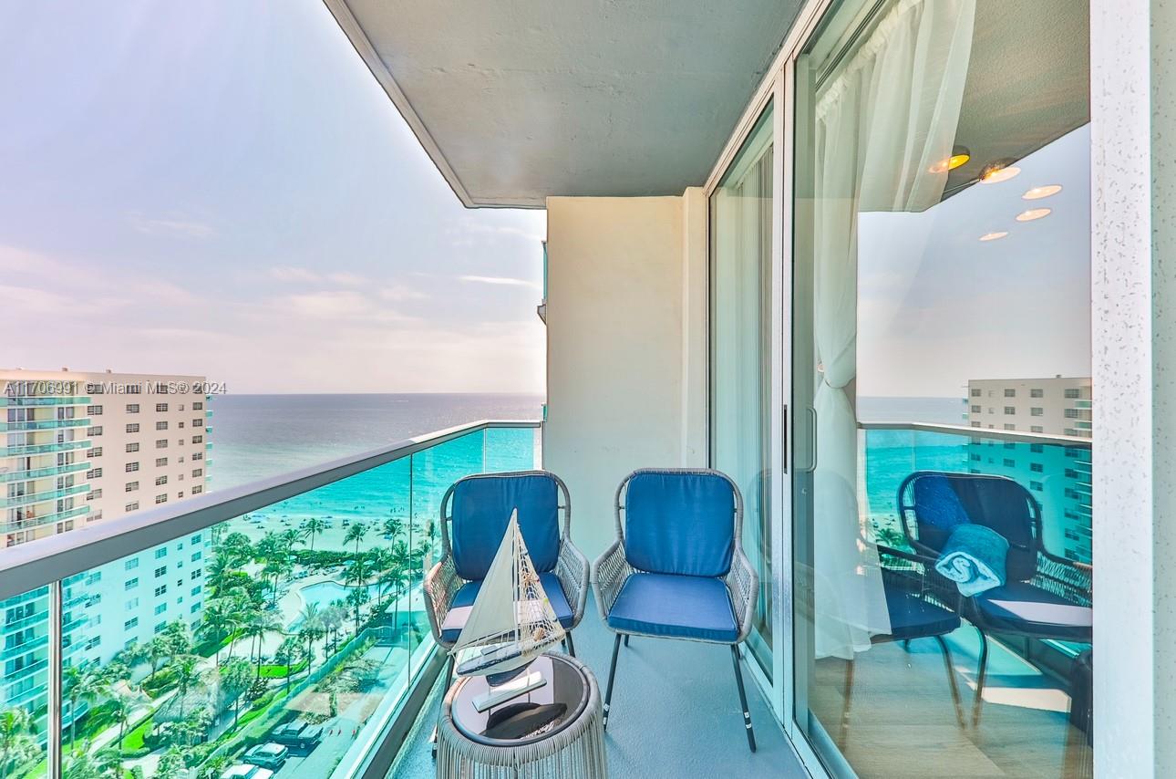 a balcony view with a large window and sitting space