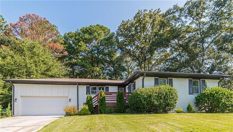 a front view of house with yard and trees around