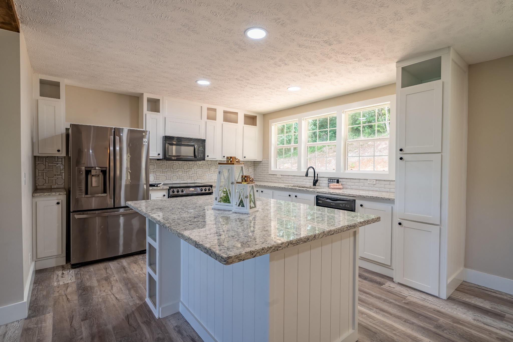 a kitchen with stainless steel appliances granite countertop a sink stove and refrigerator