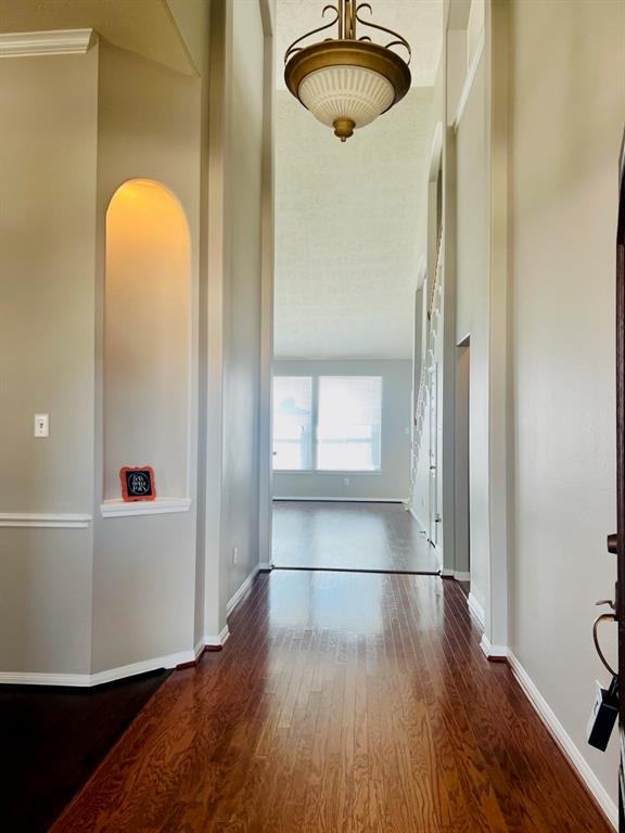 Welcome home to an elegant foyer featuring high ceilings, classic hardwood floors, and abundant natural light, inviting you into a harmonious blend of comfort and style.