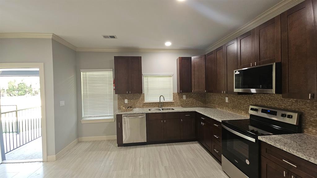 a kitchen with stainless steel appliances granite countertop a sink stove microwave and cabinets