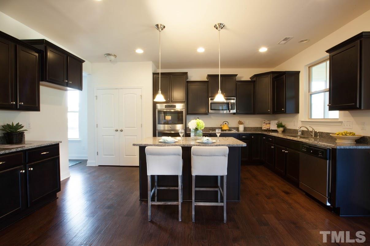 a large kitchen with a table and chairs