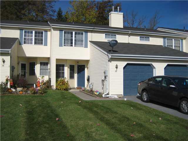 View of front of house featuring a garage and a front lawn and own private driveway.