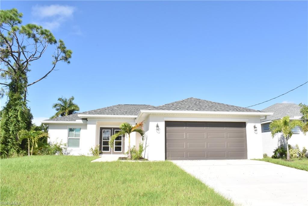 a front view of a house with a yard and garage