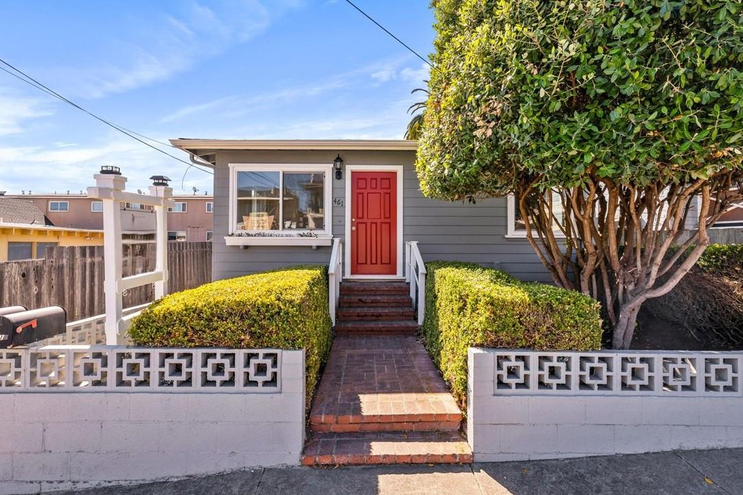 a view of a house with wooden fence next to a yard