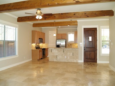 a view of a living room with kitchen island and natural light