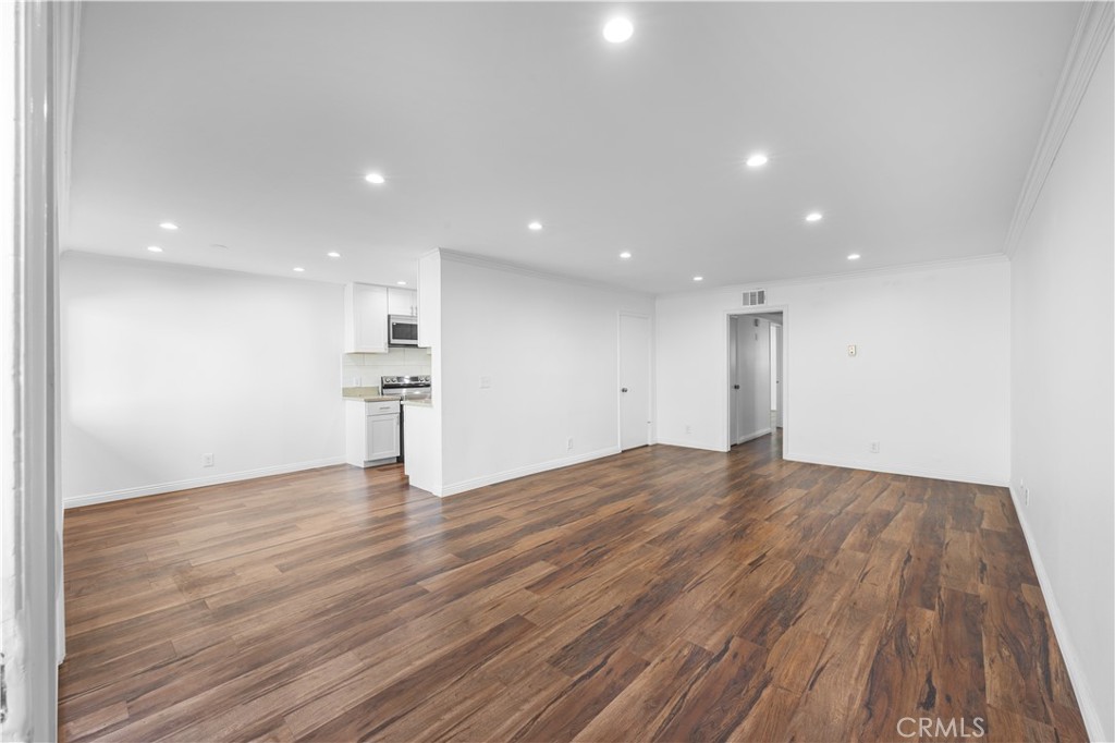 a view of empty room with wooden floor