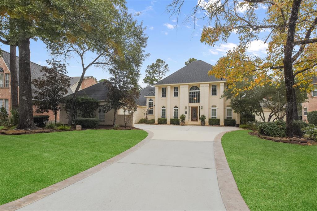 a front view of a house with a yard and trees