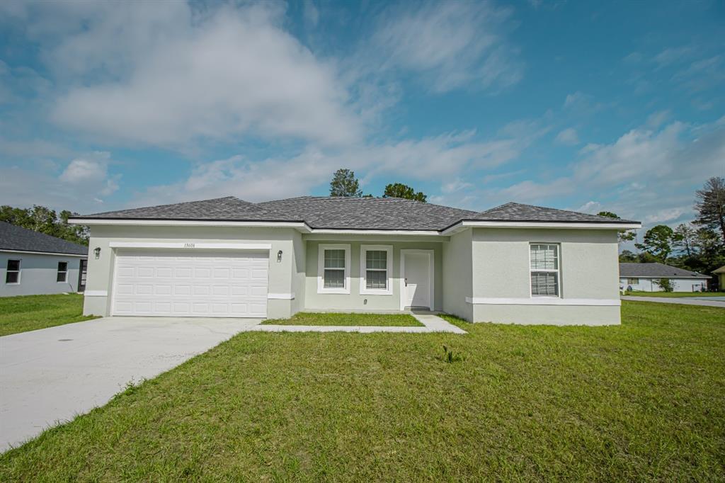 a front view of house with yard and garage