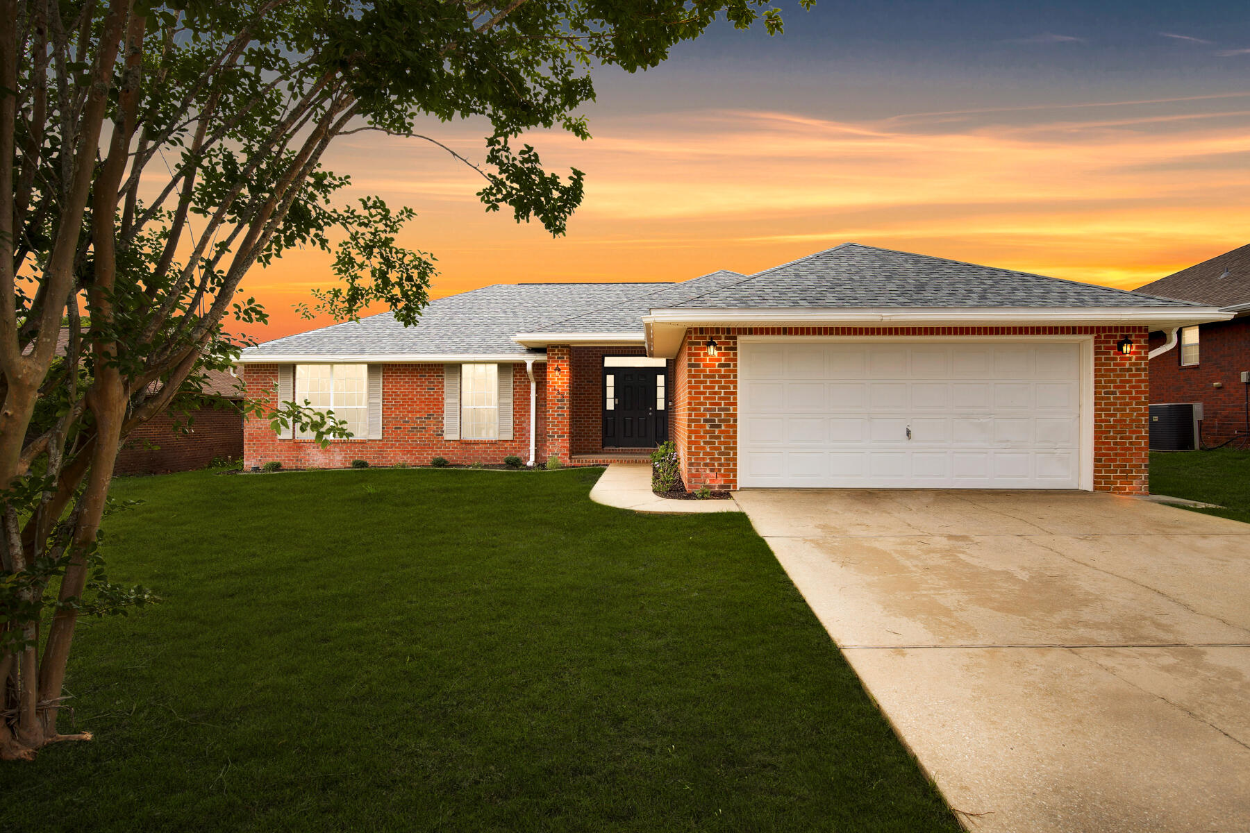 a front view of a house with a garden and yard