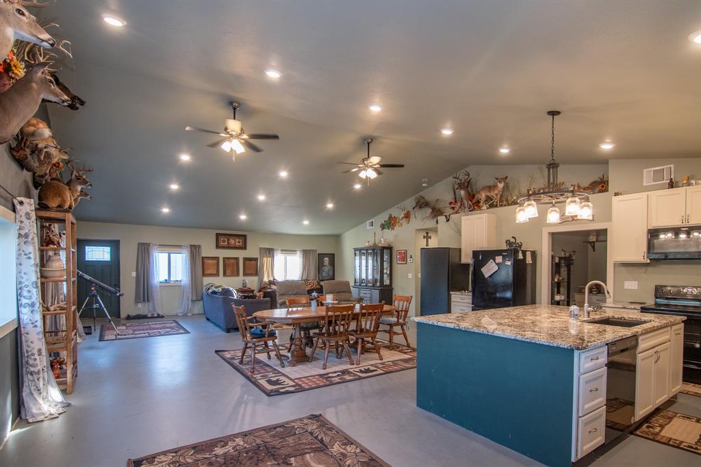 a view of a dining room with furniture a kitchen and chandelier