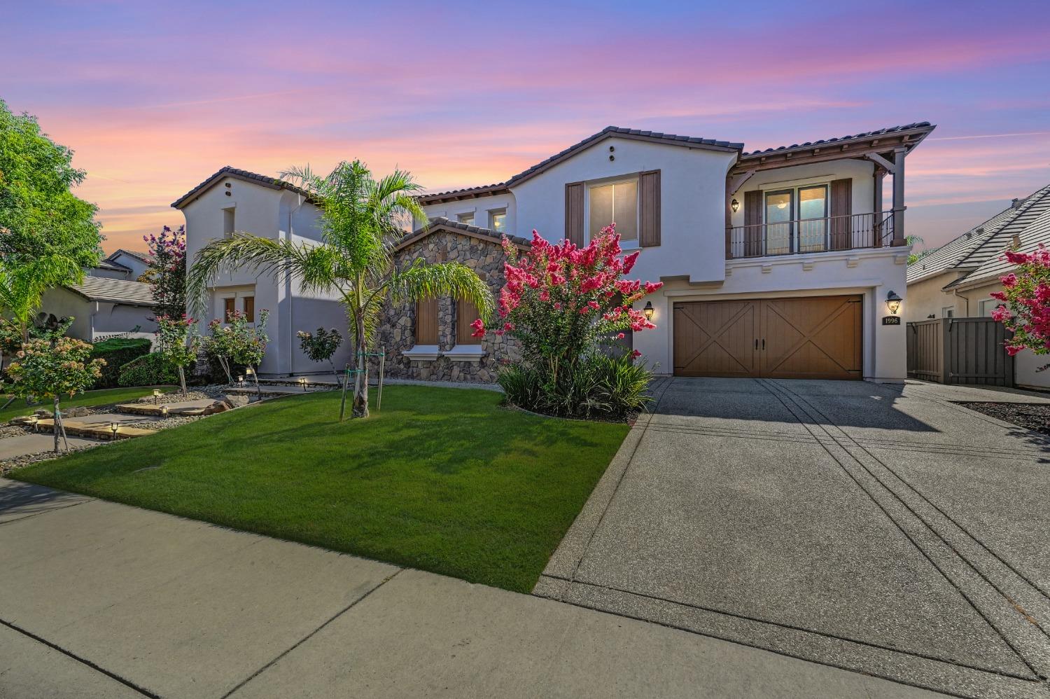 a front view of a house with a yard and a garage