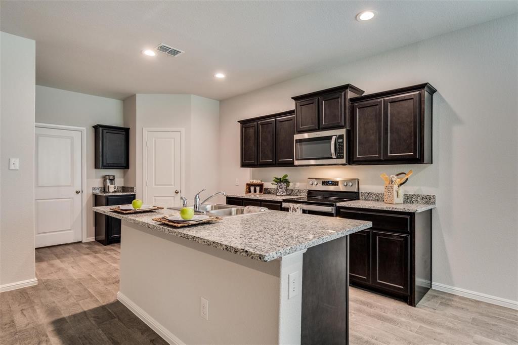 a kitchen with kitchen island granite countertop stainless steel appliances and stove top oven