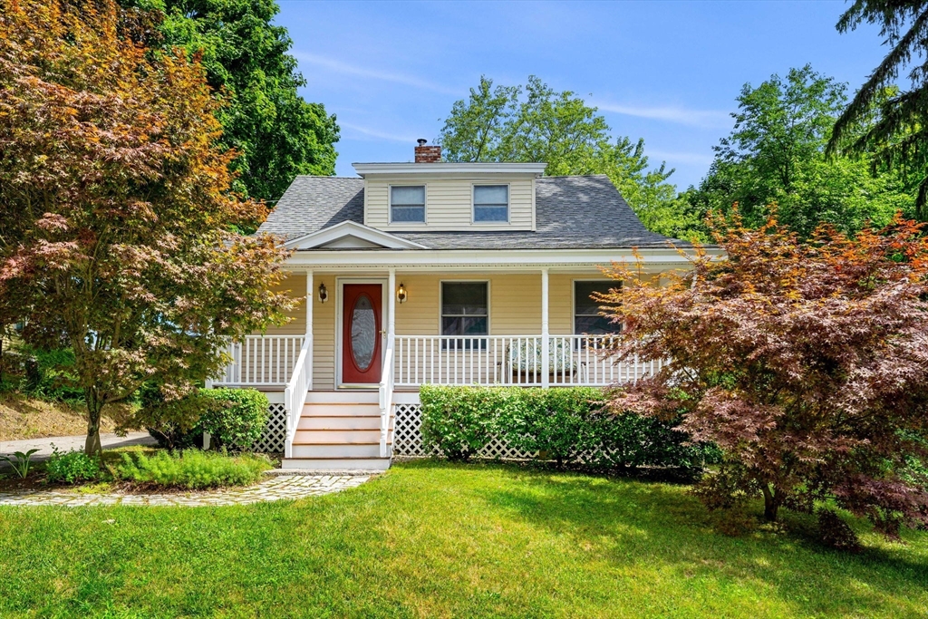 a front view of a house with a yard and trees