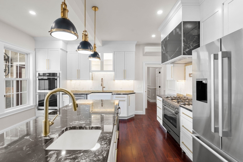 a kitchen with stainless steel appliances granite countertop a stove refrigerator and a view of living room