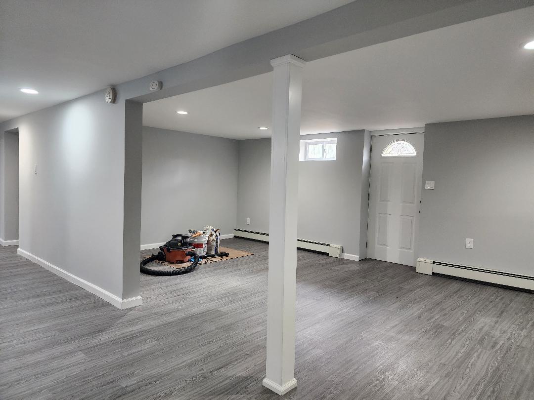 Basement with baseboard heating and hardwood / wood-style flooring