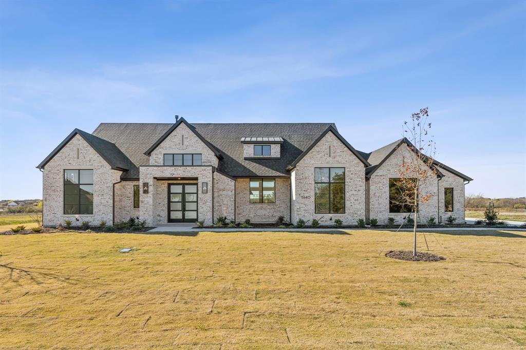 View of front of home featuring french doors and a front lawn