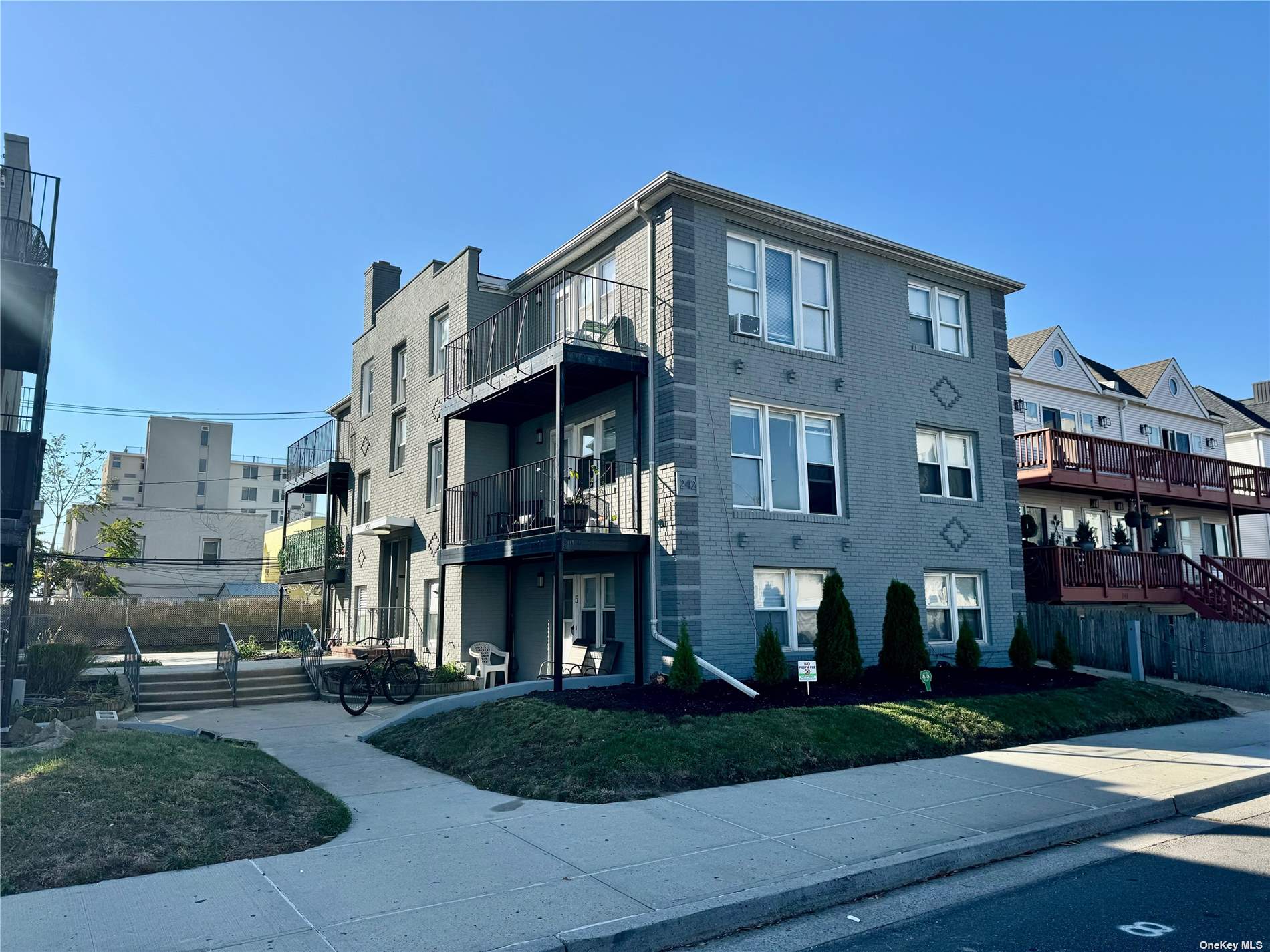 a front view of a residential apartment building with a yard