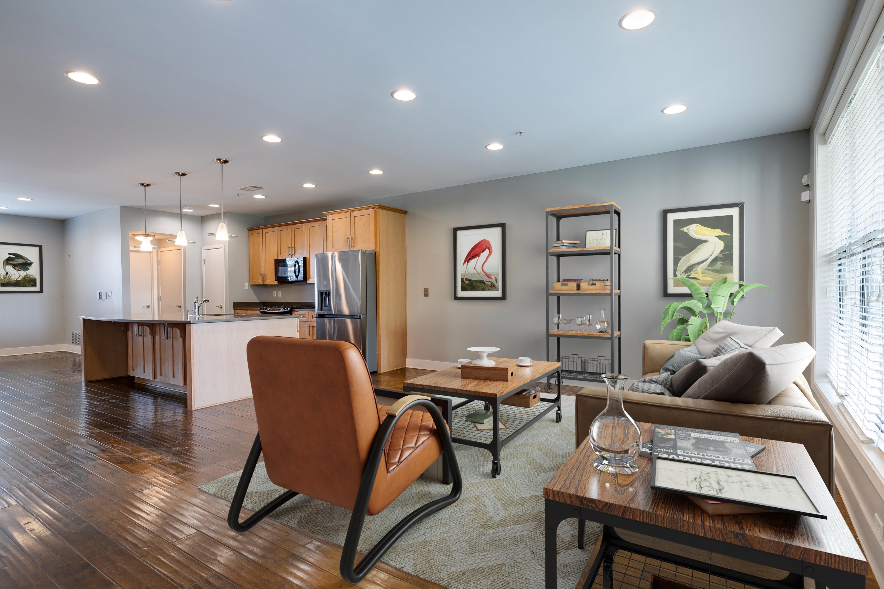 a living room with furniture and kitchen view with wooden floor